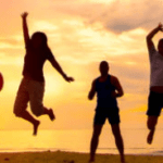 Personnes joyeuses sautant devant le soleil